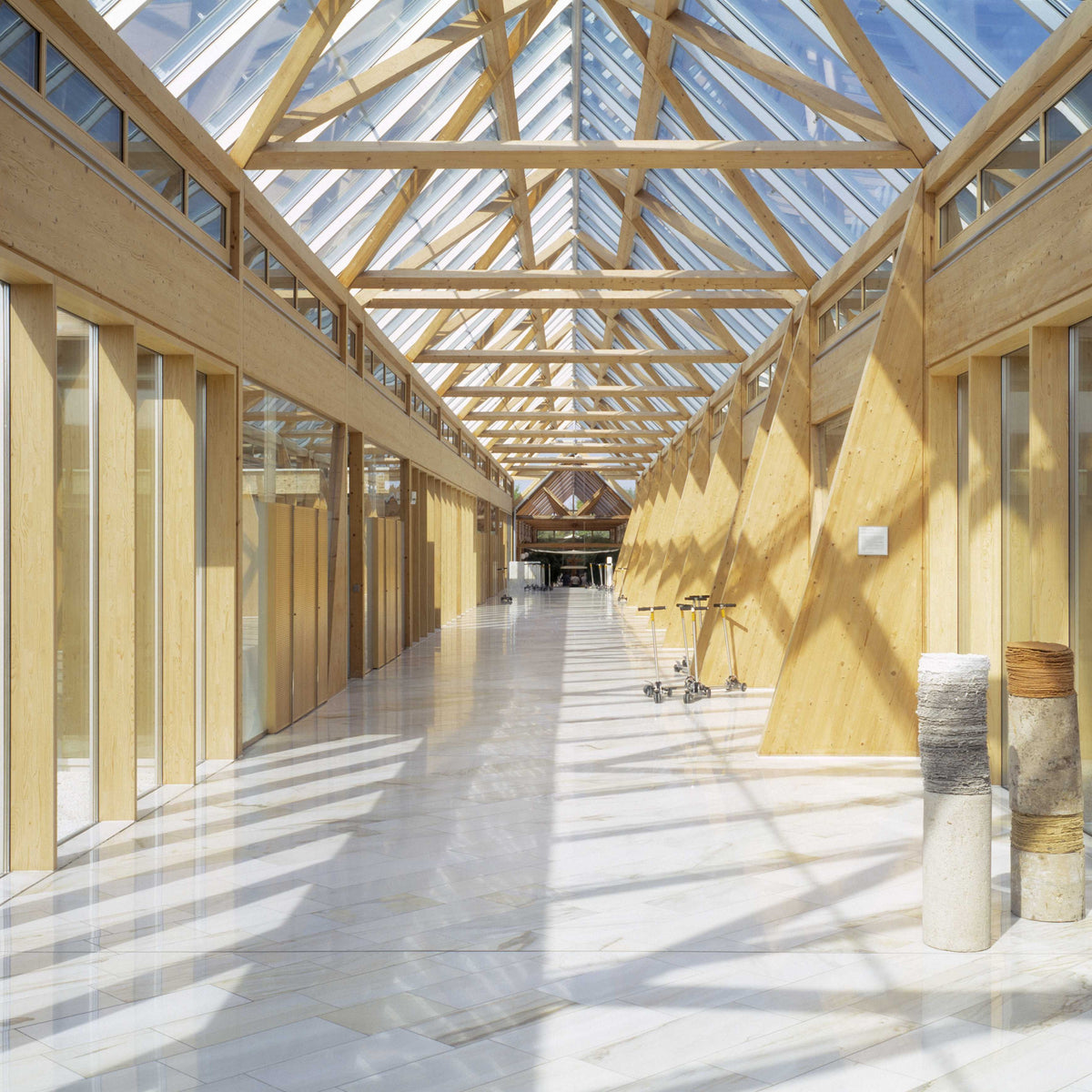 Bright wooden interior with glass roof and long corridor inside the MAC Jeans headquarters.