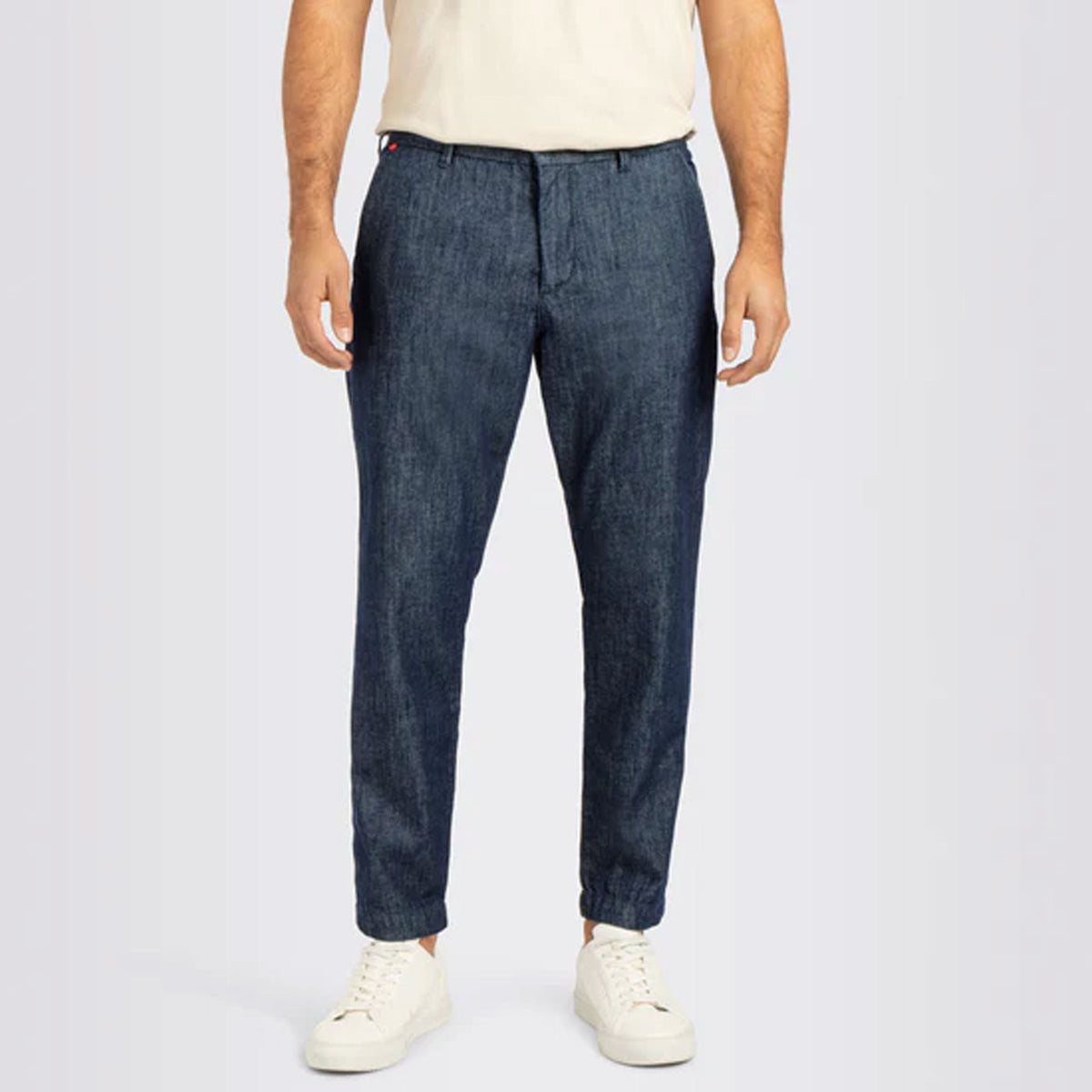 Front view of Dean men’s jeans in dark blue denim styled with a light T-shirt and white sneakers.