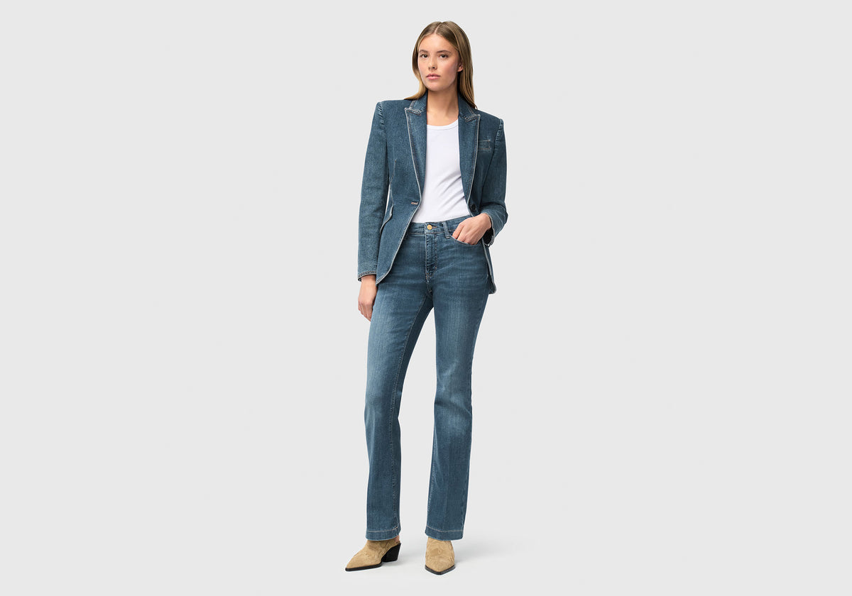 Woman wearing Dream Boot with narrow leg opening and light blue wash, modern and figure-hugging.