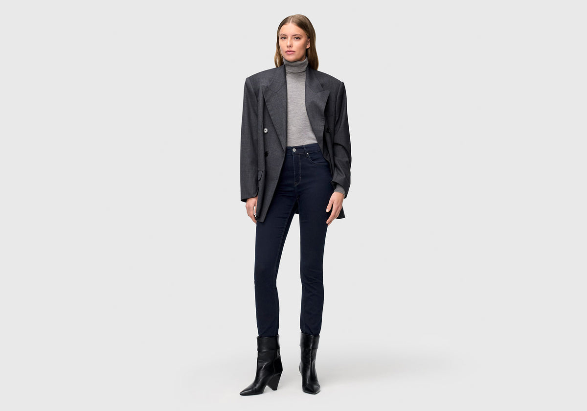 Woman wearing Dream Skinny with a close-fitting leg and dark blue wash, styled with blazer and boots.