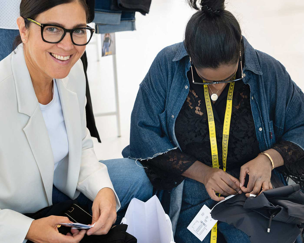 MAC design team members working with garments, measuring and adjusting details during the design process.