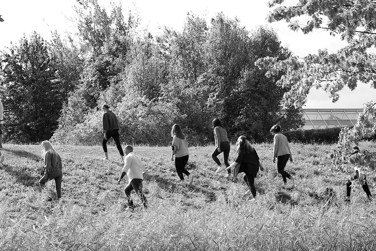 MAC employees walking together through a natural outdoor landscape.