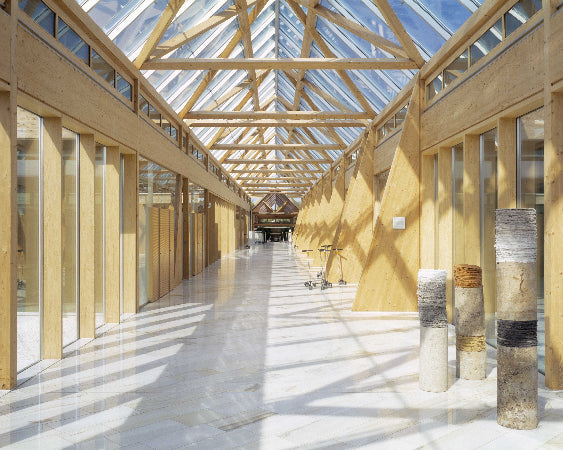 Bright wooden interior with glass roof, long corridor and modern architectural design.